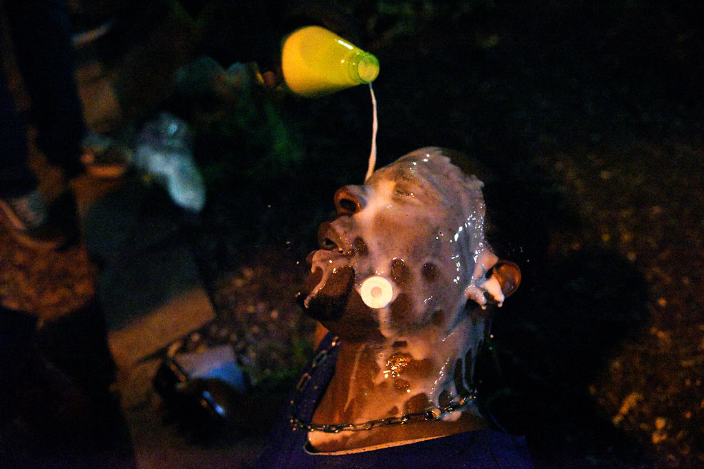 A protestor is treated with milk to ease the burn of pepper spray